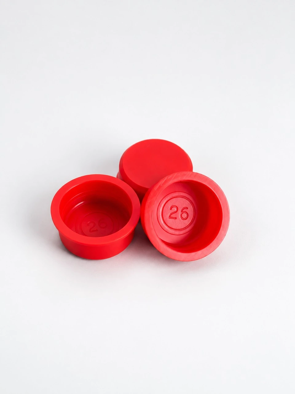 Drei rote HDPE-Stopfen mit 26-mm-Prägung in Vorder- und Rückansicht